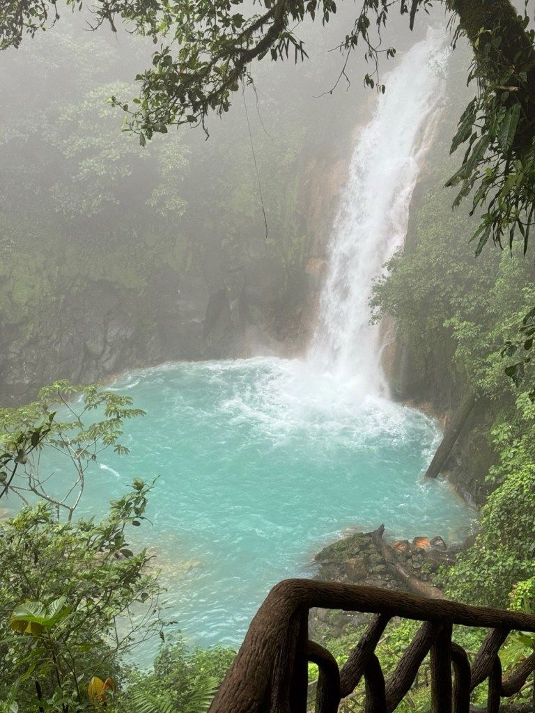 A waterfall pouring into a turquoise pool
